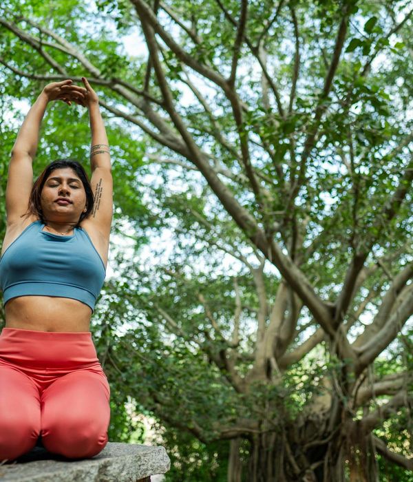 Woman practicing a calm breathing exercise in a serene natural environment.